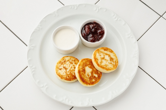 Домашние сырники со сметаной и клубничным вареньем