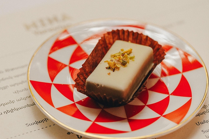 Конфета из белого шоколада с фисташкой с апельсиновым ганашем